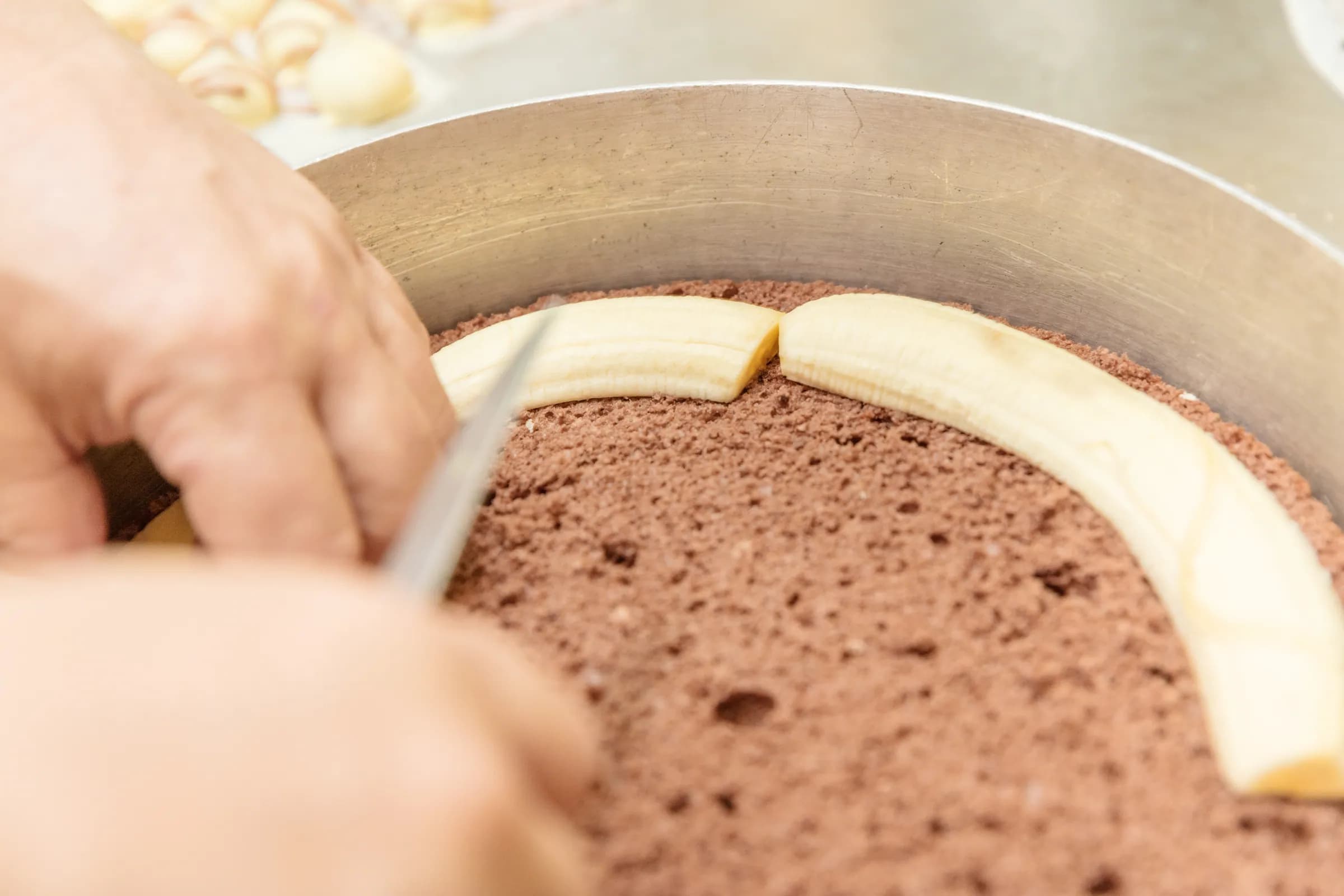 Bananen werden für die Schoko-Bananen-Sahnetorte verlegt