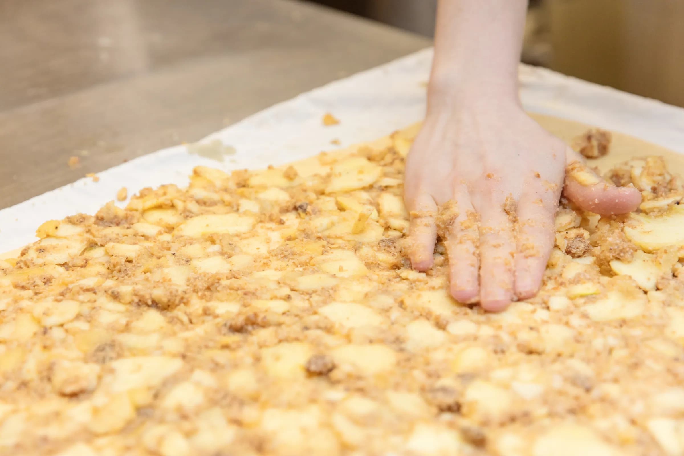 Apfelmasse wird auf dem Apfelstrudel verteilt
