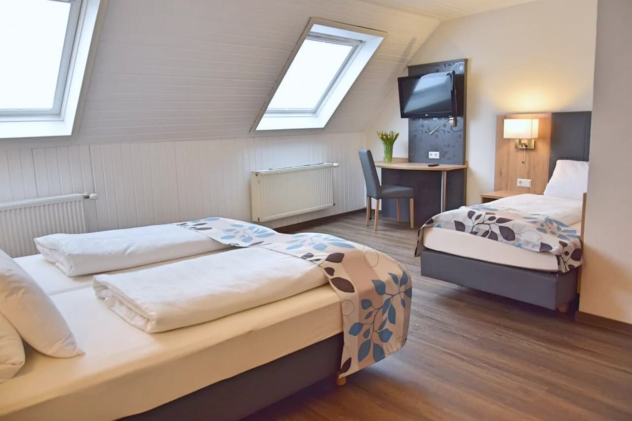 Doppel-Dreibettzimmer unterm Dach mit zwei Dachfenstern und Zustellbett